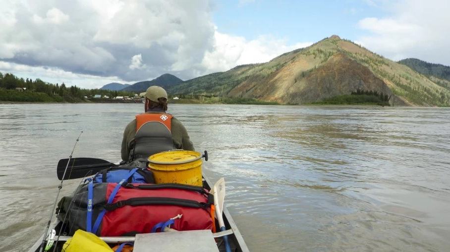 NPS / Josh Spice, canoeist setting out on the Yukon River near Eagle