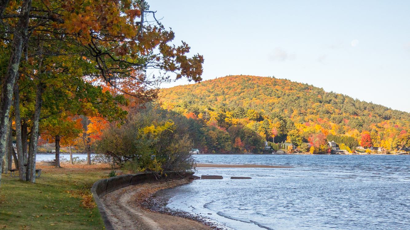 Photograph: New Hampshire State Parks, Ellacoya State Park autumn waterfront, official 2026 park imagery.